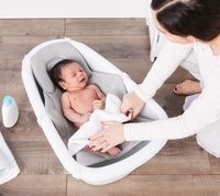 Mom dries off the baby in the Baby Basics™ Grow with Me Baby Bath Tub