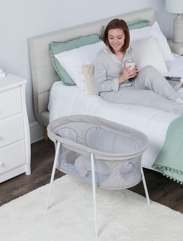 Smiling at baby in the Baby Basics™ Infant Bassinet
