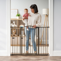 Mom holding baby behind safety gate