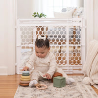 Baby playing in front of safety gate