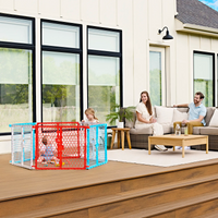 family sitting outside on the deck while the baby plays in the play yard