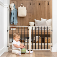 Baby sitting in front of the wooden safety gate