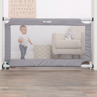 toddler playing behind safety gate