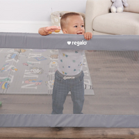 toddler playing behind safety gate