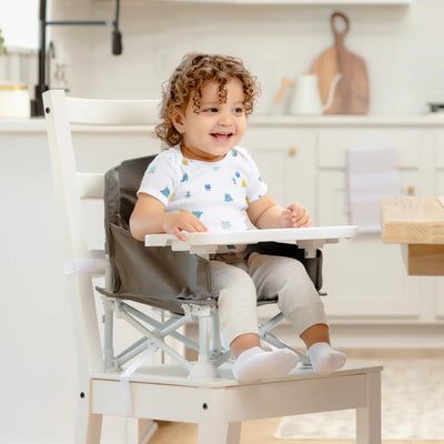 Toddler Sitting in Booster Seat on Chair at the Table 