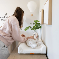Mom with baby laying on the changing pad