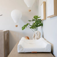 Infant changing pad on dresser in nursery