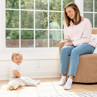 Baby sitting by mom on the floor