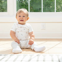Baby sitting in front of outlet plugs