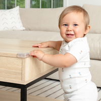 Clear Corner Cushion on coffee table with baby standing by