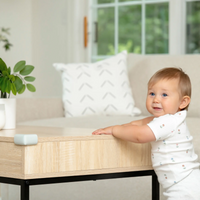 Corner Cushion on coffee table with baby standing by
