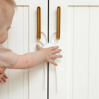 Toddler reaching for flex lock on cabinet