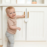 Toddler standing by cabinet with flex lock attached.