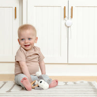 Toddler sitting in front of cabinet with flex lock on it.
