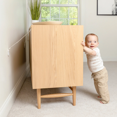 Toddler standing up on dresser with anchor straps attached to it