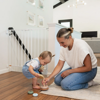 toddler playing with mom on the floor by the stairs 