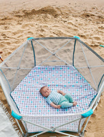 Baby rests in 6-panel My Play Portable Play Yard® with Pad