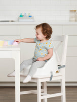 Baby playing at the table in the Baby Basics™ Booster Seat