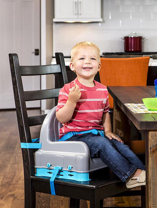Child smiles while seated in Right Height Adjustable Booster Seat