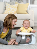 Baby smiles in My Little Seat® 2-in-1 Floor and Booster Seat - Gray